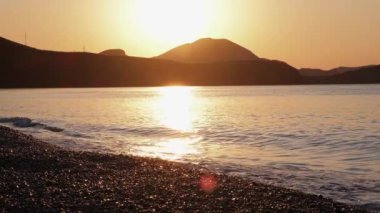 Denizin üzerinde dramatik bir gün doğumu, deniz manzarası, manzara. Yavaş çekim. Deniz dalgası. Gel-git. Sarı. - Günaydın. Sörf.