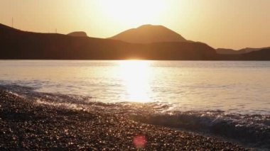 Denizin üzerinde dramatik bir gün doğumu, deniz manzarası, manzara. Yavaş çekim. Deniz dalgası. Gel-git. Sarı. - Günaydın. Sörf.