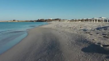 Kıyı kasabasına doğru güzel kumsalın üzerinden uçuyor. 