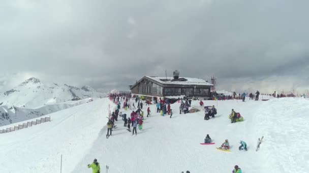 높은 눈덮인 산들 이라. 크라 스투야 폴리아나. 스키 리조트. 눈. 스키와 스노보드. 공중 촬영 비디오. 구름. 눈. 산꼭대기. — 비디오