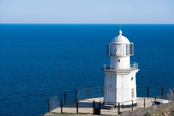 Білий маяк проти блакитного моря.. — стокове фото