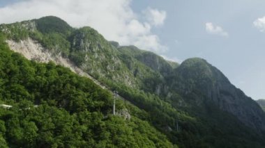 Güzel yüksek dağlar. Yeşil ağaçlar. Açık mavi gökyüzü. Kuzey Kafkasyalı. Soçi. Hava videosu. Vahşi yaşam. 