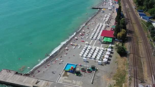 ビーチだ リゾート チェイスだ 上からの眺め 空中ビデオ 太陽からの傘 海のそばの人たち — ストック動画