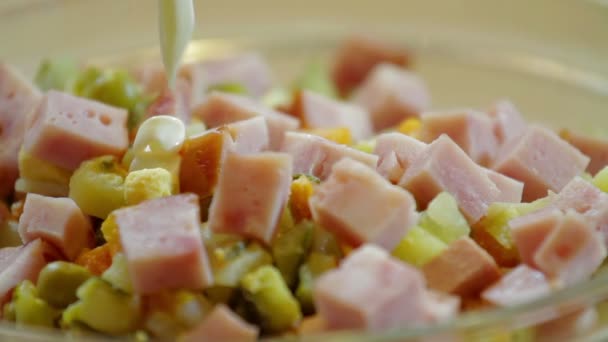 La salsa de mayonesa se vierte en ensalada con guisantes verdes y salchichas — Vídeo de stock
