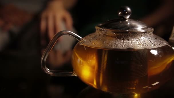 Té. Verter té saludable. Tetera y taza de té de vidrio en la mesa — Vídeos de Stock