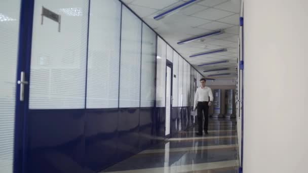 Hombre de negocios caminando por el pasillo de la oficina — Vídeo de stock