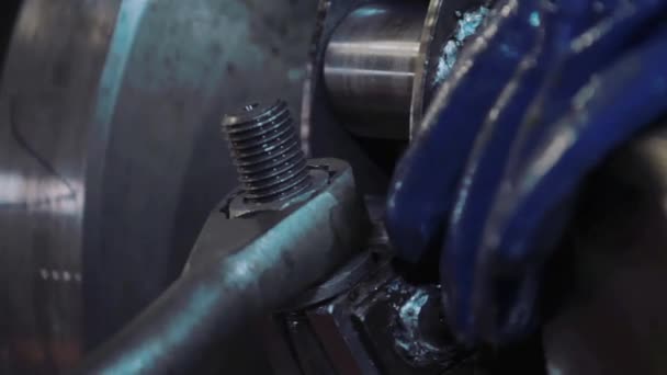労働者は金属レンチでボルトを締めます。金属加工CNCフライス盤工場で金属の詳細を生成します。青い手袋の労働者は、マシン内のワークを修正します — ストック動画