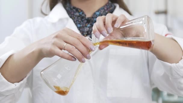 Langzame beweging van vrouwelijke wetenschapper analyseert vloeistof in distilleerderij laboratorium onderzoeker. Langzame beweging van het mengen van chemicaliën en alcoholische drank. Analyse van whiskymonster op laboratoriumapparatuur. — Stockvideo