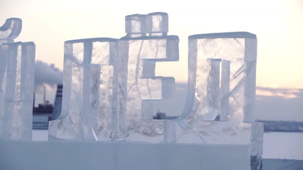 Skulptur ord Is i ryska språket som har skurits ut från isen. Isskulpturer i Ryssland. Skulpturer I Isstaden vid solnedgången. — Stockvideo