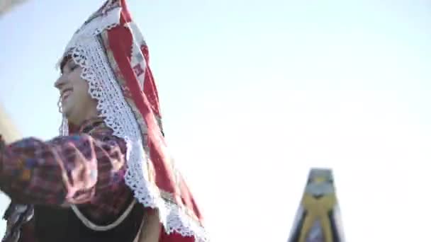 러시아의 전통 의상을 입은 사람들은 오래 된 전통 목조 풍차 배경을 가지고 옥외에서 춤을 추고 있습니다. 피노 우그 릭 국립 옷을 입고 있는 행복 한 사람들의 그룹. — 비디오
