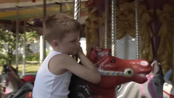 İnanılmaz rengarenk bir atlıkarınca panayırı. Lunaparkta sirk atı gezintisi. Mutlu çocuk atlı karıncaya biniyor.. — Stok video