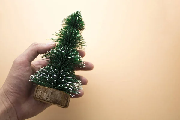Hand pick kerstboom op achtergrond — Stockfoto
