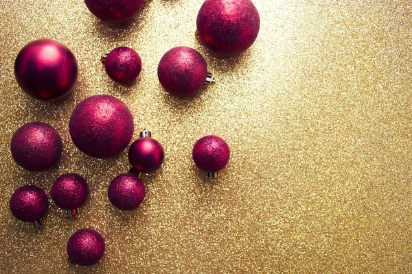 Червоний блискучий кульковий декор на золотому фоні — стокове фото