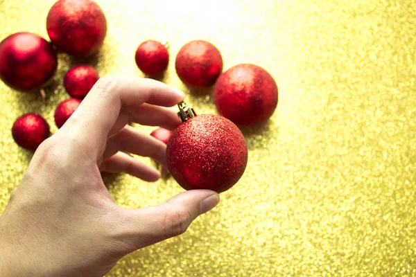 Повесить красный декор глайтер мяч на золотом фоне — стоковое фото
