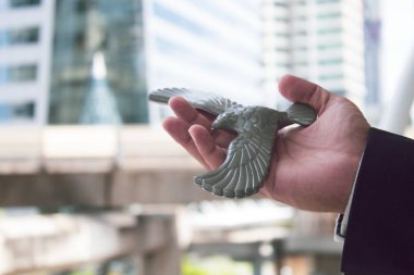 İş adamı, lider konsepti ve finansal risk ticareti için kartal oyuncağını iş vizyonunda tutuyor.