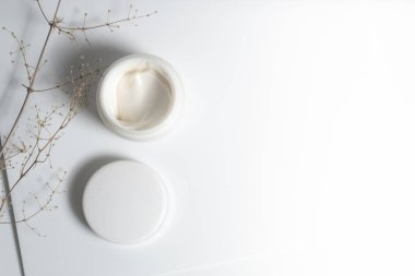 Güzellik spası tıbbi cilt bakımı ve kozmetik krem serumu. Beyaz dekor arka planında yağ modeli şişesi ambalajı. Kolajen sağlık sigortası konsepti.