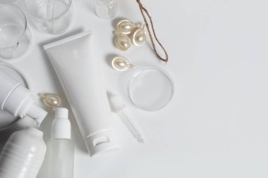 Güzellik tedavisi medikal cilt bakımı ve kozmetik krem serumu. Beyaz dekor arka planı, sağlık ve tıp konsepti üzerine yağ taklit şişesi ambalajlama ürünü.
