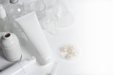 Güzellik tedavisi medikal cilt bakımı ve kozmetik krem serumu. Beyaz dekor arka planı, sağlık ve tıp konsepti üzerine yağ taklit şişesi ambalajlama ürünü.