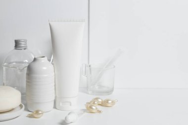 Güzellik tedavisi medikal cilt bakımı ve kozmetik krem serumu. Beyaz dekor arka planı, sağlık ve tıp konsepti üzerine yağ taklit şişesi ambalajlama ürünü.