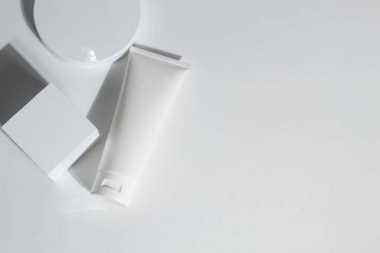 Güzellik tedavisi medikal cilt bakımı ve kozmetik krem serumu. Beyaz dekor arka planı, sağlık ve tıp konsepti üzerine yağ taklit şişesi ambalajlama ürünü.