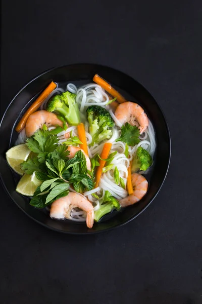 Азіатська рисова локшина, креветки та овочевий суп у мисці — стокове фото