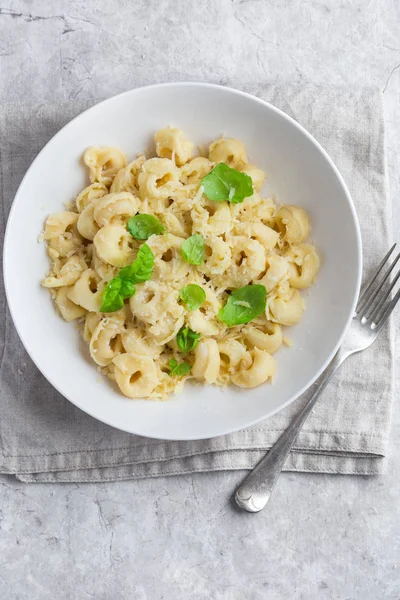 Ost tortellini serveras med parmesan och basilika — Stockfoto