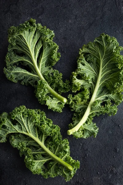 Fresh green organic kale leaves on dark background — Stock Photo, Image