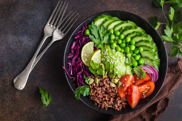 Comida vegetariana. Aguacate, arroz rojo, tomate, pepino, col roja — Foto de Stock