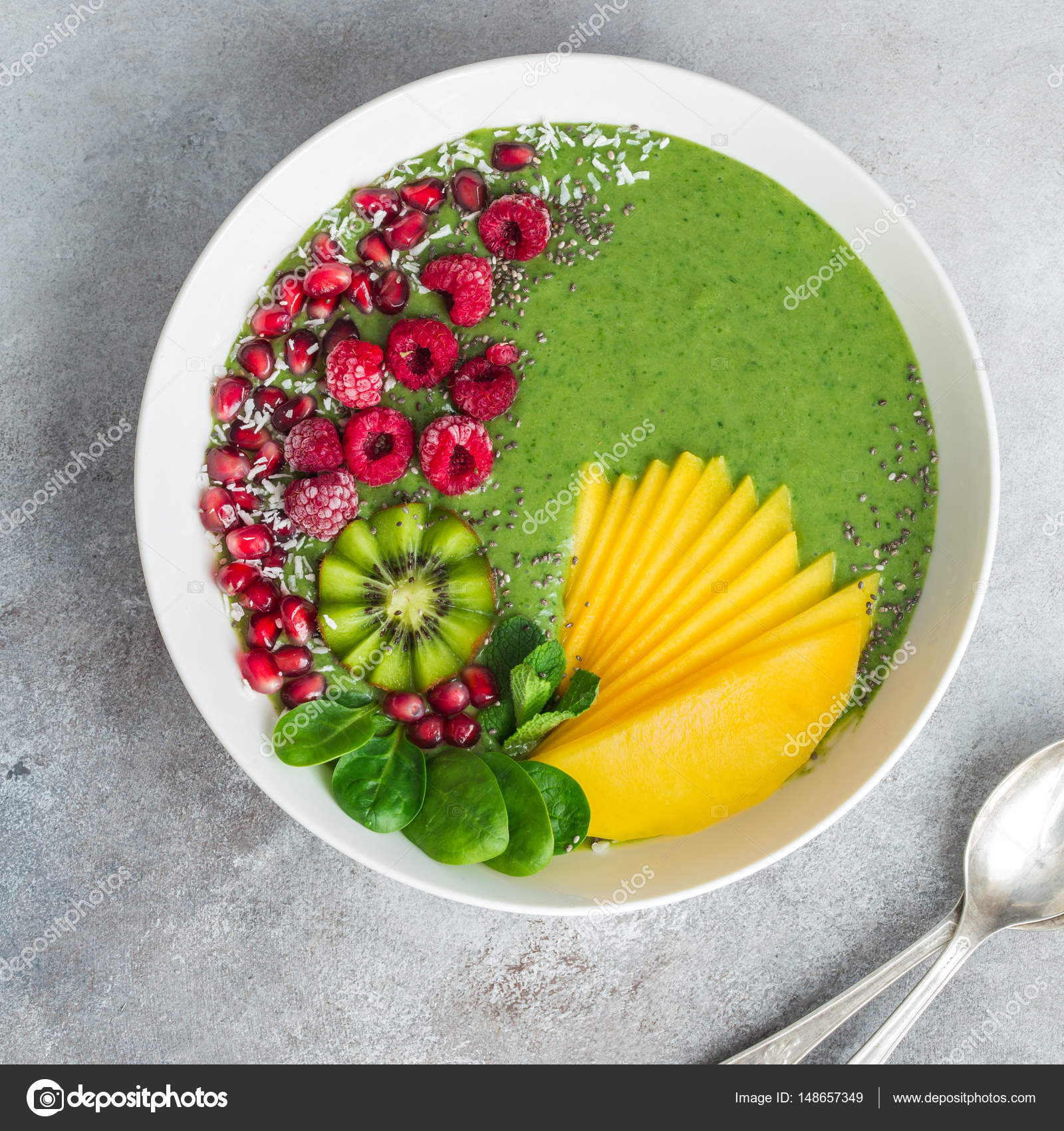 Green smoothie bowl with spinach, mango, kiwi and raspberry. Hea