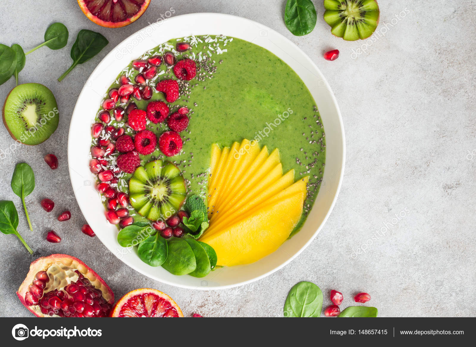 Fresh green smoothie bowl with spinach, mango, kiwi and raspberr