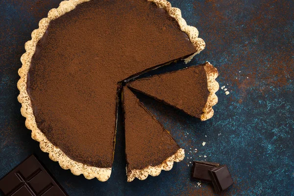 Chocolate and caramel tart on dark blue background — Stock Photo, Image