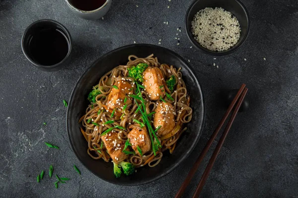 Aziatische soba noedels en teriyaki zalm in zwarte kom — Stockfoto