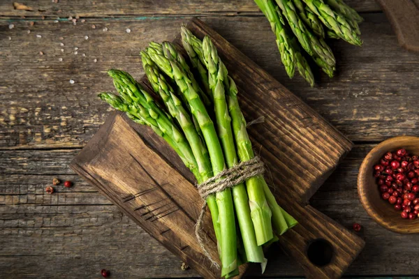 Banches of fresh green asparagus on wooden background — Stock Photo, Image