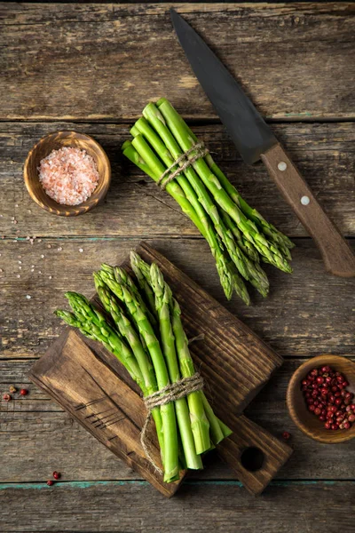 Bankette mit frischem grünen Spargel auf hölzernem Hintergrund — Stockfoto