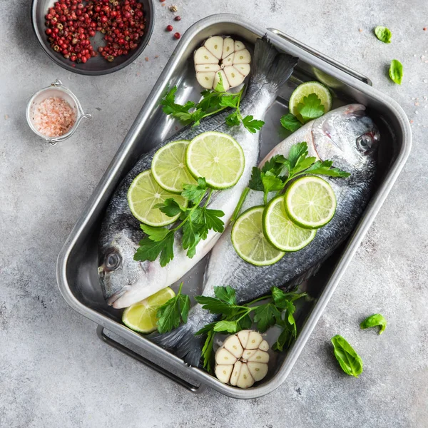 Two raw dorado fish with lime and parsley ready to cooking — Stock Photo, Image