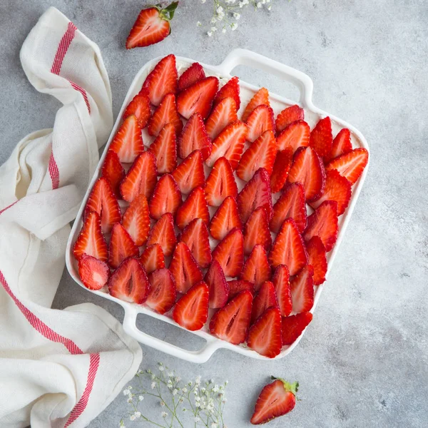 Biskuitteig mit Frischkäse und frischen Erdbeeren auf weißem Bak — Stockfoto