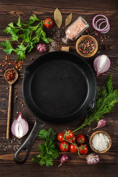 Herbs and spices around cast iron skillet — Stock Photo, Image