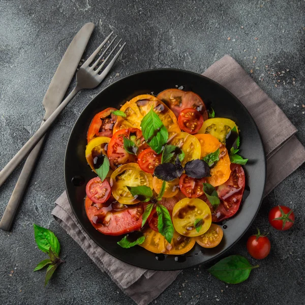 Colorful tomatoes salad with basil and basamic vinegar — Stock Photo, Image