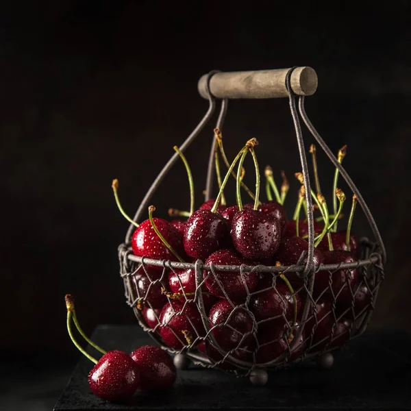 Fresh sweet cherry on basket, selective focus, black background — Stock Photo, Image