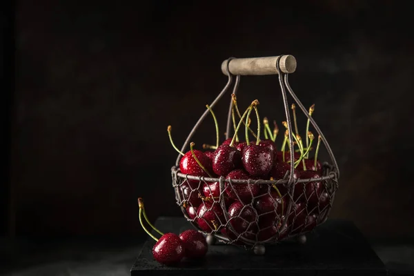 Fresh sweet cherry on basket, selective focus, black background — Stock Photo, Image