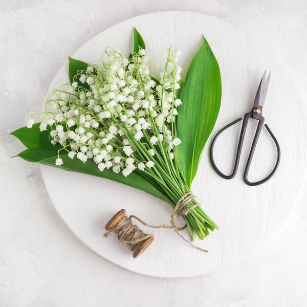 Liljekonvalj blommor på vit träskiva — Stockfoto