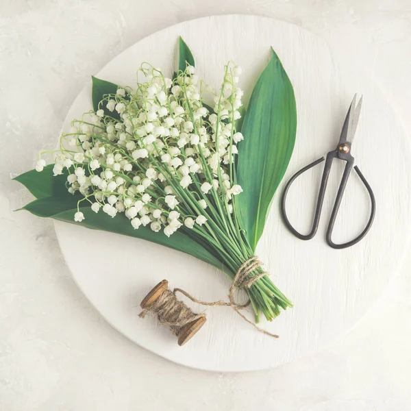 Flatlay of Lily of the valley flowers on white wooden tray — Stock Photo, Image