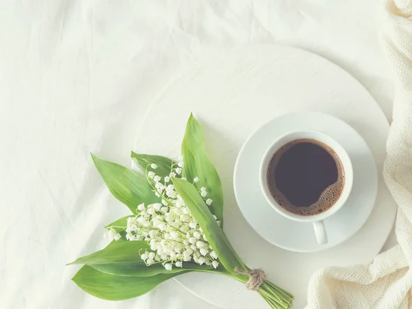 Desayuno en la cama. taza de café y lirio del valle — Foto de Stock