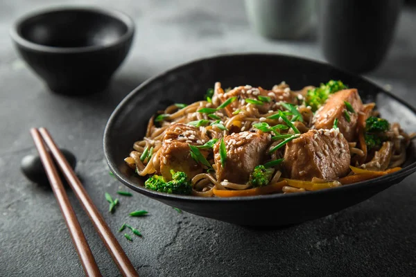 Aziatische soba noedels en teriyaki zalm in zwarte kom — Stockfoto