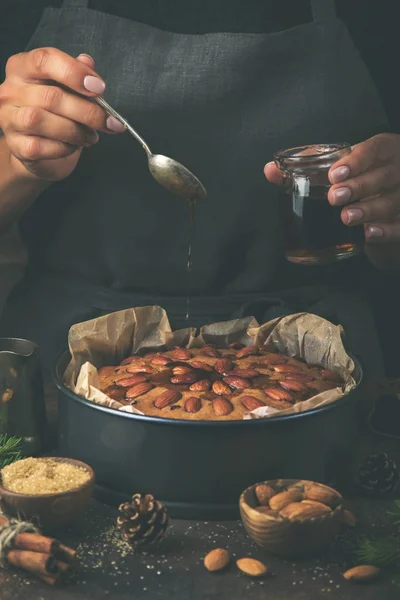 Boże Narodzenie ciasto owocowe. Kobieta wylewa ciemny rum na ciasto — Zdjęcie stockowe