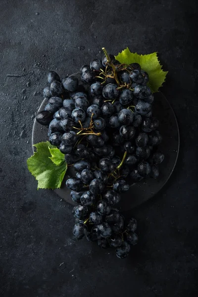 Свіжий стиглий чорний виноград на темному бетонному фоні — стокове фото