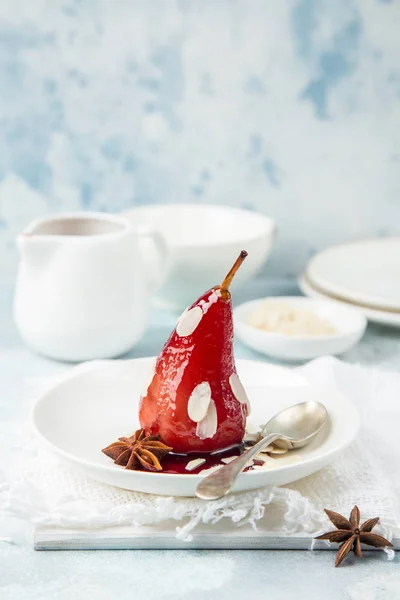 Pochierte Birnen in würzigem Rotweinsirup serviert mit Mandelflocken — Stockfoto