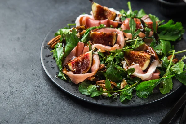 Prosciutto, figs, arugula, goat cheese salad with pecan nuts and — Stock Photo, Image