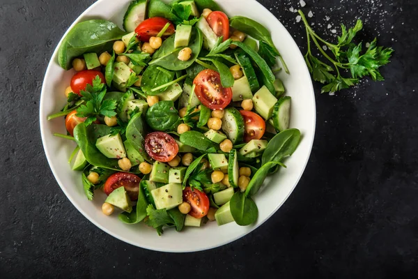 Avokado, tomat, kikärtor, spenat och gurka sallad — Stockfoto