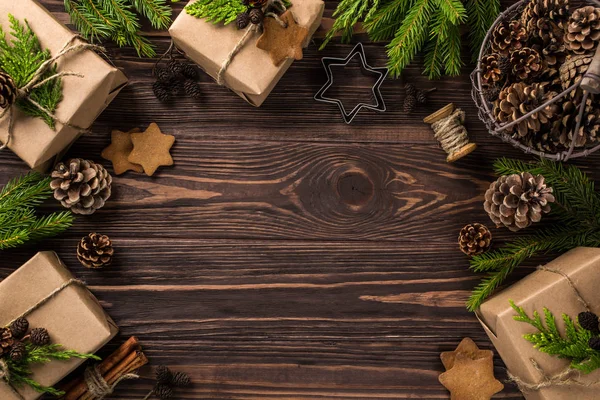 Weihnachtsgeschenke in Kraftpapier gewickelt und Dekoration auf Holz — Stockfoto